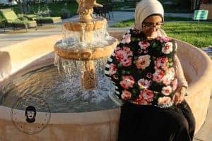 Wearing a multi-use nursing cover next to a fountain